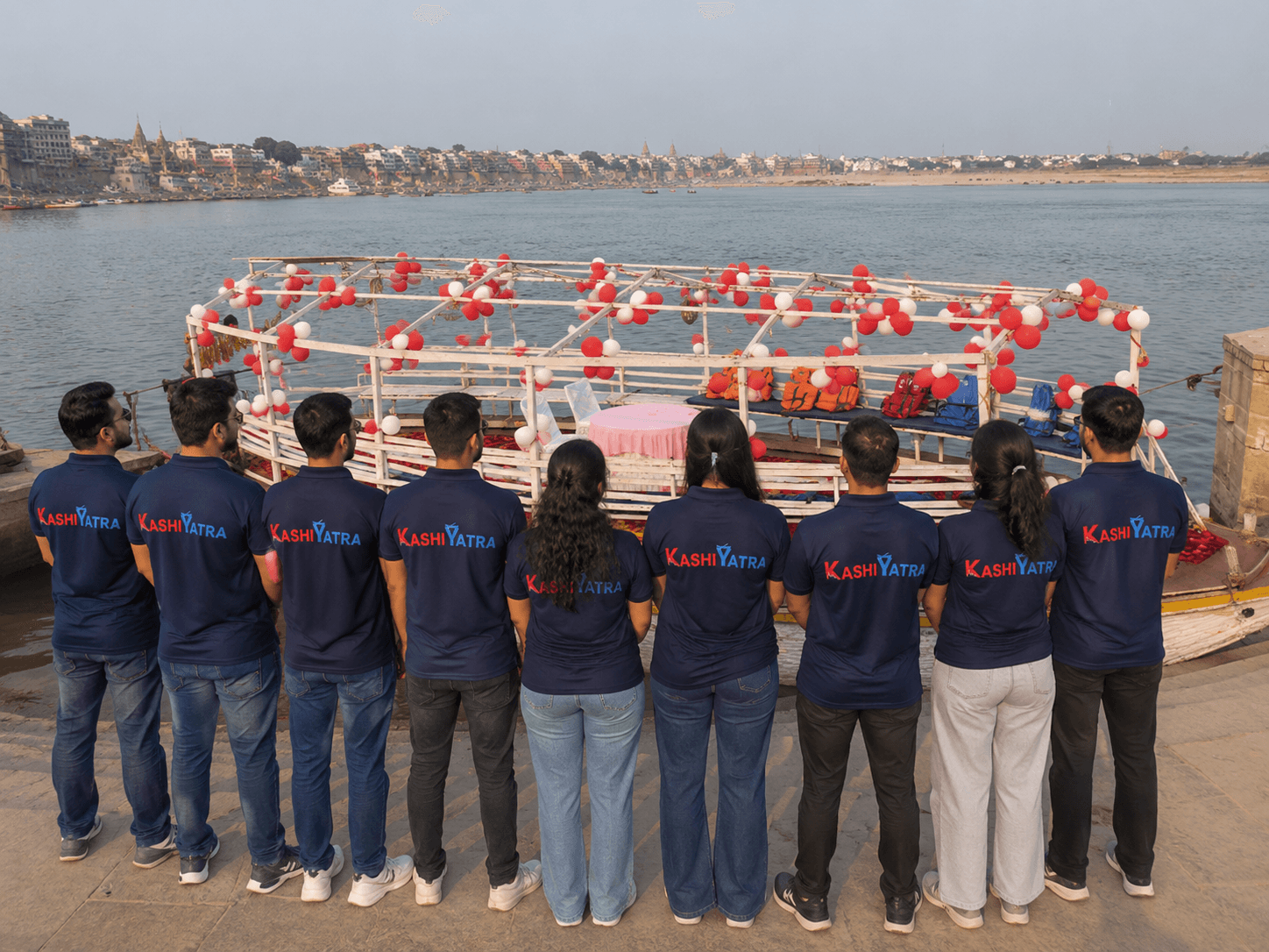 KashiYatra team on a ghat beside a decorated boat